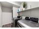 Laundry room features modern washer and dryer set, wood look floors and white shelving at 4650 Ridgeley Ave # 103, North Las Vegas, NV 89084