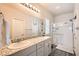 Bathroom featuring a double vanity with granite countertops and a walk-in shower with glass doors at 4720 Flower Moon Ave # 101, North Las Vegas, NV 89084
