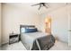 Comfortable bedroom with a ceiling fan and a gray comforter, leading into an ensuite bathroom at 4720 Flower Moon Ave # 101, North Las Vegas, NV 89084