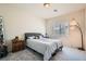 Cozy bedroom with a gray upholstered headboard, carpet flooring, and a unique floor lamp at 4720 Flower Moon Ave # 101, North Las Vegas, NV 89084
