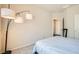 Inviting bedroom with light-colored walls, carpet flooring, and a large floor lamp at 4720 Flower Moon Ave # 101, North Las Vegas, NV 89084
