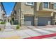 Close-up of a townhome showcasing attached garages and well-manicured landscaping at 4720 Flower Moon Ave # 101, North Las Vegas, NV 89084