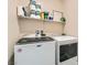 Laundry room with a modern washer and dryer, featuring overhead storage shelving at 4720 Flower Moon Ave # 101, North Las Vegas, NV 89084