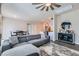 Inviting living space with a gray sofa, modern ceiling fan, and an open layout leading to the kitchen at 4720 Flower Moon Ave # 101, North Las Vegas, NV 89084