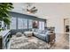 Bright living room featuring a plush gray sectional sofa, a modern ceiling fan, and stylish decor at 4720 Flower Moon Ave # 101, North Las Vegas, NV 89084