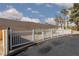 A white picket fence surrounds the property with secure entrance and desert landscaping at 5114 S Jones Blvd # 202, Las Vegas, NV 89118