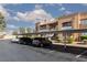 Exterior view of a two-story condo with covered parking and desert landscaping under a partly cloudy sky at 5114 S Jones Blvd # 202, Las Vegas, NV 89118