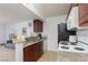 Kitchen with granite countertops, stainless sink, white appliances, and dark brown cabinetry at 5114 S Jones Blvd # 202, Las Vegas, NV 89118
