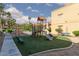 Community playground featuring a slide, monkey bars, and benches surrounded by grassy area at 5114 S Jones Blvd # 202, Las Vegas, NV 89118