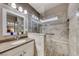 Bright bathroom featuring granite countertop vanity and a spacious tiled shower with built-in seat at 52 Vallejo Verde St, Henderson, NV 89012
