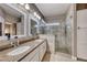 Elegant bathroom with double vanity, granite countertop, and glass enclosed shower with seating at 52 Vallejo Verde St, Henderson, NV 89012