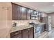 Modern kitchen with granite counters, stainless steel appliances, breakfast bar, and dark wood cabinetry at 52 Vallejo Verde St, Henderson, NV 89012