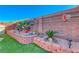 Manicured landscaping with colorful plants, unique garden decor, and vibrant synthetic turf at 52 Vallejo Verde St, Henderson, NV 89012
