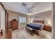 Relaxing main bedroom with wood-look floors, ceiling fan, and natural light from a shuttered window at 52 Vallejo Verde St, Henderson, NV 89012