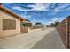 View of backyard featuring a large concrete area, metal shed, brick wall, and covered patio at 5202 Willis St, North Las Vegas, NV 89031