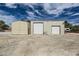 Exterior shot of workshop and sheds with white doors and siding and a large concrete pad at 5202 Willis St, North Las Vegas, NV 89031