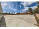 Expansive lot featuring a spacious concrete parking area, outbuildings, mature trees, and block wall at 5202 Willis St, North Las Vegas, NV 89031
