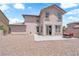 Exterior home elevation featuring a patio area with outdoor seating in the gravel backyard at 5960 Addy Ln, North Las Vegas, NV 89081