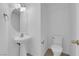 Cozy half-bathroom with white fixtures, a pedestal sink, and tiled floors, perfect for guests at 5960 Addy Ln, North Las Vegas, NV 89081