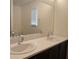 Bright bathroom featuring a double sink vanity, sleek countertops, and a large mirror with natural light at 6830 Truffle Gray St, Las Vegas, NV 89148