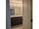 This bathroom features double sinks, modern fixtures and a large mirror over dark cabinets at 6830 Truffle Gray St, Las Vegas, NV 89148