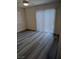 Bright bedroom with wood flooring, a sliding glass door, and a window with white blinds at 6830 Truffle Gray St, Las Vegas, NV 89148