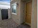 Front entrance area features a gravel groundcover, stylish wall-mounted light fixture, and neutral exterior paint at 6830 Truffle Gray St, Las Vegas, NV 89148