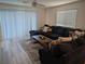 Spacious living room with a dark large sofa, large windows, and stylish decor at 6830 Truffle Gray St, Las Vegas, NV 89148