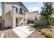 Backyard with a small patio area, artificial grass, and desert landscaping at 7047 Sombra Way, Las Vegas, NV 89113