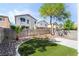 Large backyard featuring an artificial lawn, patio, and well-maintained landscaping at 7047 Sombra Way, Las Vegas, NV 89113
