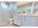 Bathroom with double sinks, white cabinets and a shower with glass door at 7047 Sombra Way, Las Vegas, NV 89113