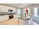 Modern kitchen featuring stainless steel appliances, gray countertops, and white cabinets at 7047 Sombra Way, Las Vegas, NV 89113
