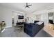 Bright living room features gray carpet, high ceilings, ceiling fan, TV, and modern furniture at 7047 Sombra Way, Las Vegas, NV 89113