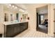 This bright bathroom features a double sink vanity, walk-in closet and access to the bedroom at 707 Cottonwood Hill Pl, Henderson, NV 89011