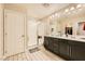 The bright bathroom has a double sink vanity with a glass-enclosed shower and a walk-in closet at 707 Cottonwood Hill Pl, Henderson, NV 89011