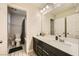 Well-lit bathroom features modern vanity with a white countertop, dark cabinetry and a framed mirror at 707 Cottonwood Hill Pl, Henderson, NV 89011