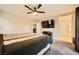 This bedroom features neutral walls and carpet, a ceiling fan, a TV and an attached bathroom at 707 Cottonwood Hill Pl, Henderson, NV 89011