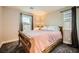 This bedroom has two windows, carpeted floors and is decorated with a wooden bedframe and lamp at 707 Cottonwood Hill Pl, Henderson, NV 89011