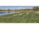 Scenic community pond featuring a pathway, lush green grass, and a mountain view at 707 Cottonwood Hill Pl, Henderson, NV 89011