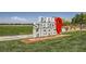 A vibrant community sign set against a backdrop of lush green grass and distant city views at 707 Cottonwood Hill Pl, Henderson, NV 89011
