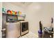 Bright laundry room with modern washer and dryer, complemented by shelves for storage at 707 Cottonwood Hill Pl, Henderson, NV 89011