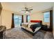 Spacious main bedroom with a ceiling fan, plush carpet, and a sliding glass door for outdoor access at 707 Cottonwood Hill Pl, Henderson, NV 89011