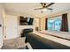 A well-lit main bedroom features plush carpeting, a ceiling fan, and access to a private balcony at 707 Cottonwood Hill Pl, Henderson, NV 89011