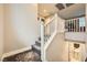 An open staircase with carpeted steps and a white railing leads to the upper level of the home at 707 Cottonwood Hill Pl, Henderson, NV 89011