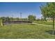 Community tennis courts surrounded by lush green lawns and mature trees at 707 Cottonwood Hill Pl, Henderson, NV 89011