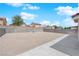 A spacious gravel backyard with a concrete patio and block wall offers a blank canvas for outdoor enjoyment at 720 Picasso Picture Ct, North Las Vegas, NV 89081