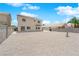 Large, gravel backyard featuring a concrete patio, bordered by a privacy block wall, offering space and potential at 720 Picasso Picture Ct, North Las Vegas, NV 89081