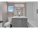 Bathroom featuring a gray vanity, framed mirror, shower-tub combo and natural light at 720 Picasso Picture Ct, North Las Vegas, NV 89081