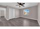 A neutral toned bedroom with wood-look flooring, ceiling fan and double door closet at 720 Picasso Picture Ct, North Las Vegas, NV 89081