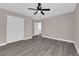 A bright bedroom showcases wood-look floors, a ceiling fan, a closet, and neutral walls at 720 Picasso Picture Ct, North Las Vegas, NV 89081